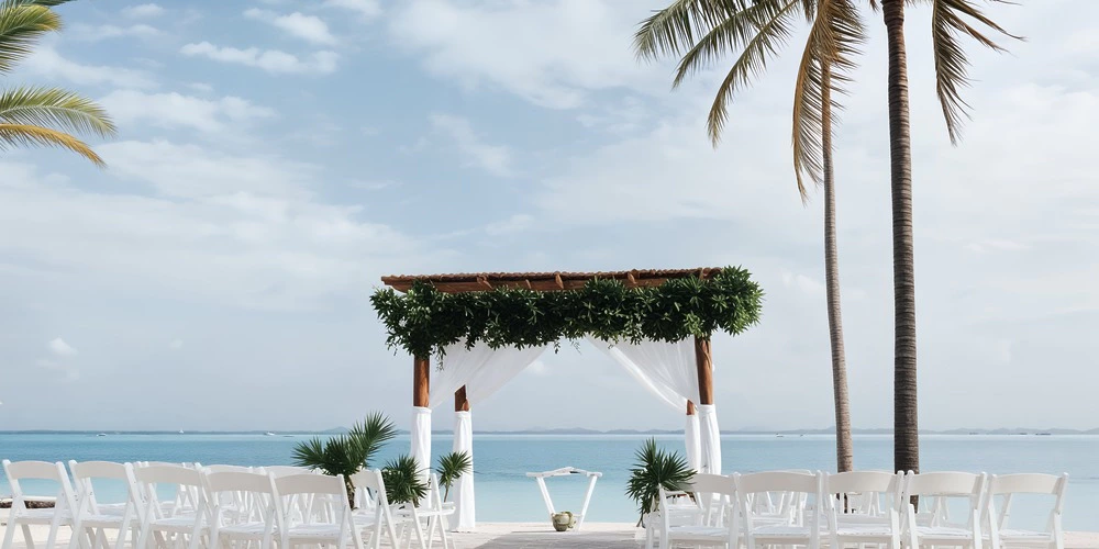 Beach pergola wedding ceremony setup with white chairs and ocean views at Secrets Akumal Riviera Maya
