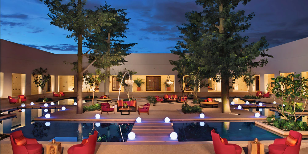 Desires Terrace evening lounge setup with glowing pool lights at Secrets Akumal Riviera Maya