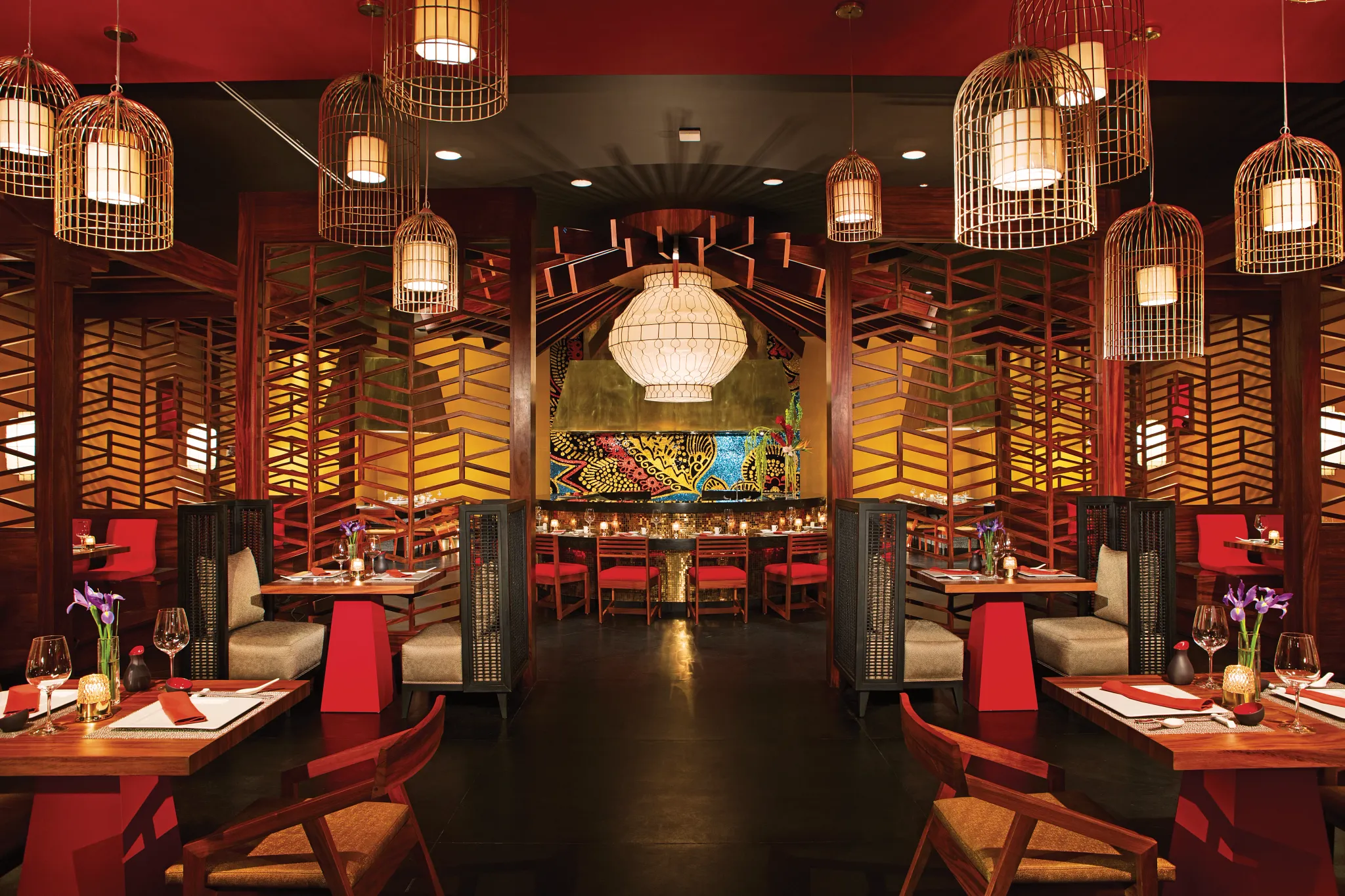 Himitsu Pan-Asian Restaurant at Secrets Akumal Riviera Maya featuring a stylish Asian fusion dining room with hanging lanterns, warm red accents, sushi bar seating, and elegant décor.