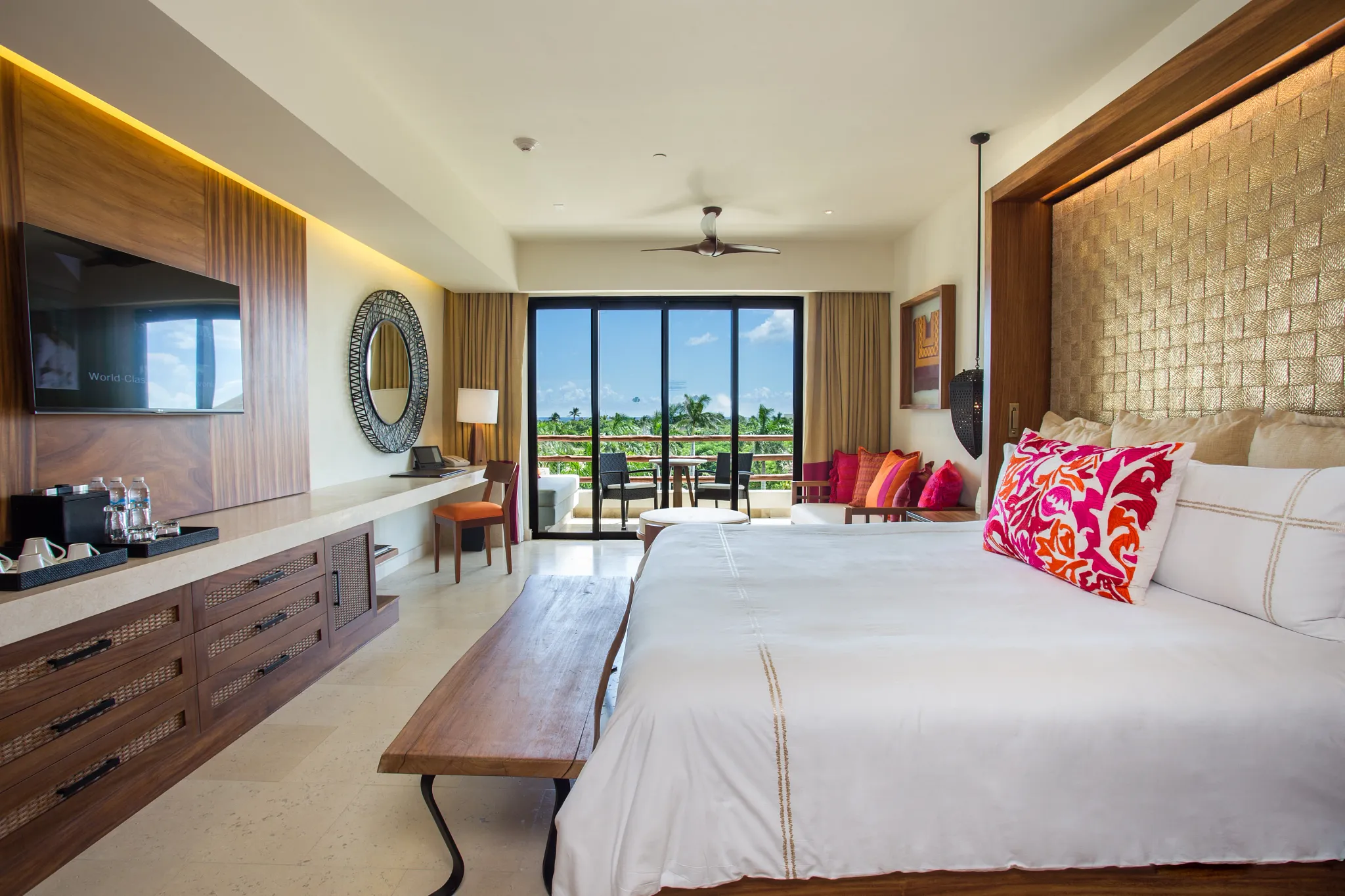 Junior Suite Partial Ocean View with king bed and sitting area at Secrets Akumal Riviera Maya overlooking the resort.