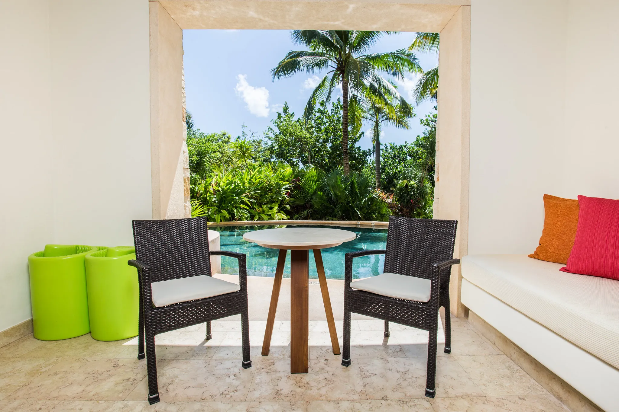 Junior Suite Swim Out terrace with table and chairs beside the pool at Secrets Akumal Riviera Maya.