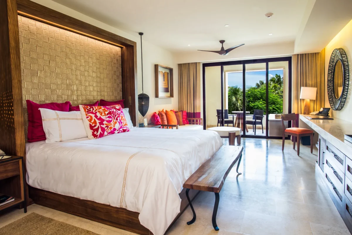 Preferred Club Junior Suite Tropical View with king bed and lounge seating at Secrets Akumal Riviera Maya.