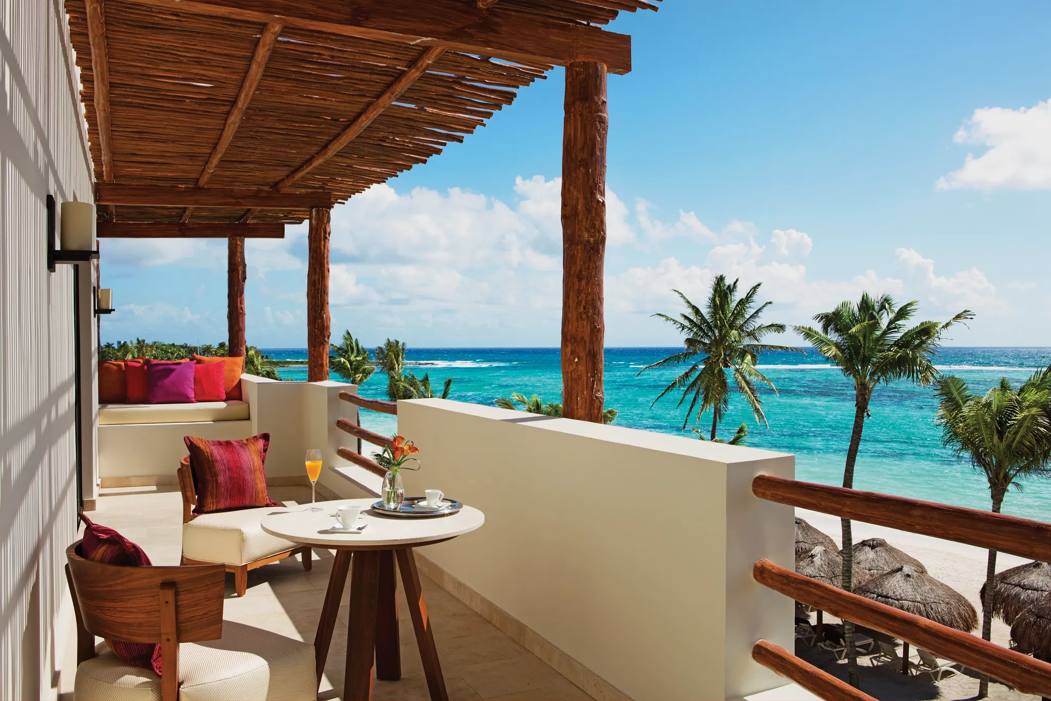 Presidential Suite oceanfront balcony with seating area and Caribbean Sea views at Secrets Akumal Riviera Maya.