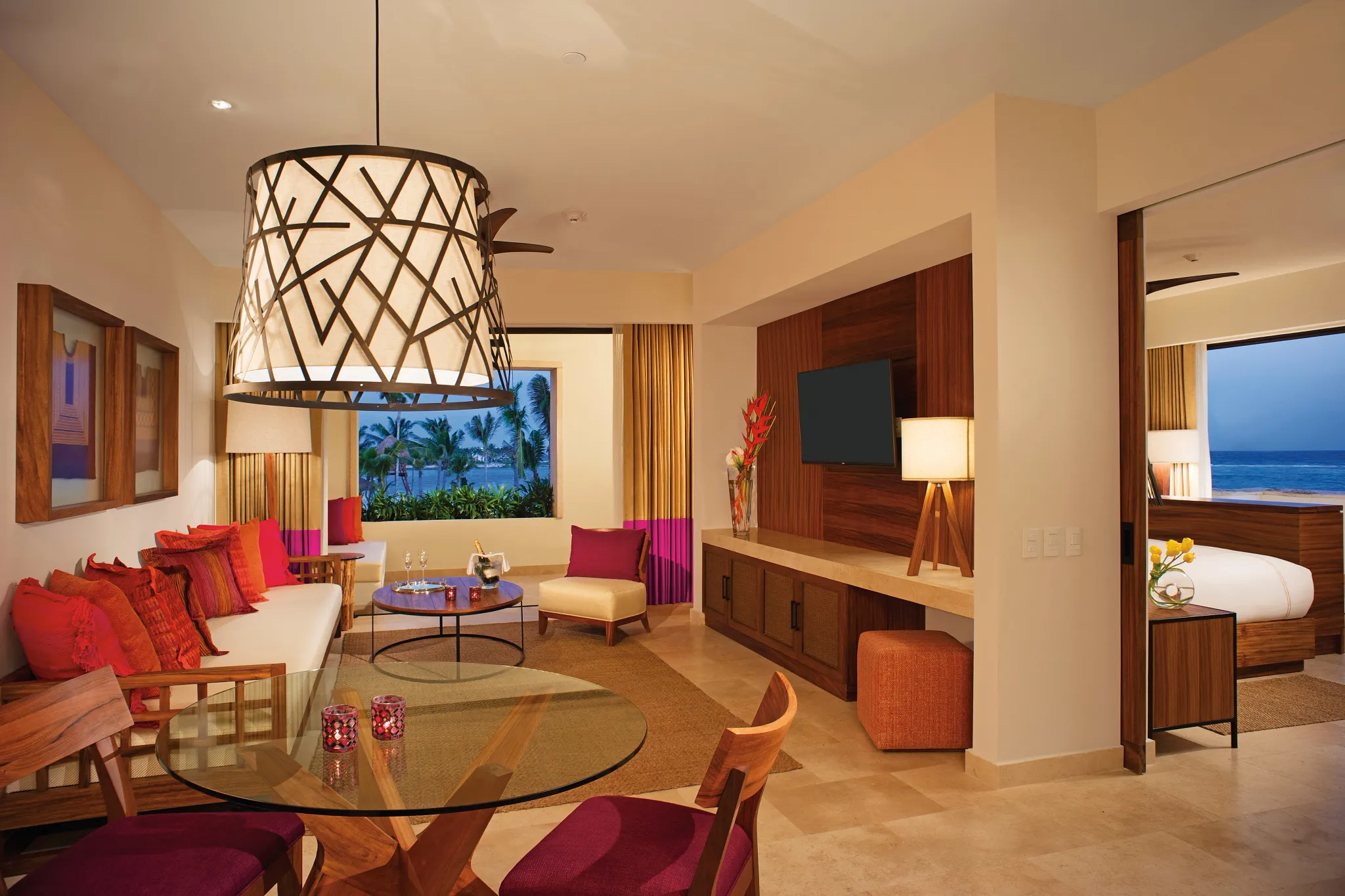 Romance Master Suite Swim Out living room with sofa, dining table, and ocean view at Secrets Akumal Riviera Maya.
