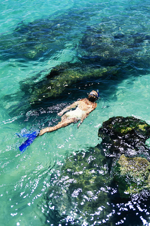 Snorkeling in crystal-clear turquoise water at Xel-Há Park near Secrets Akumal Riviera Maya in the Riviera Maya