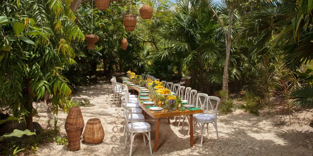 Yalku Garden outdoor reception setup with long banquet table and tropical greenery at Secrets Akumal Riviera Maya